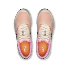 Pair of pink and white running shoes with 'on' branding on a white background