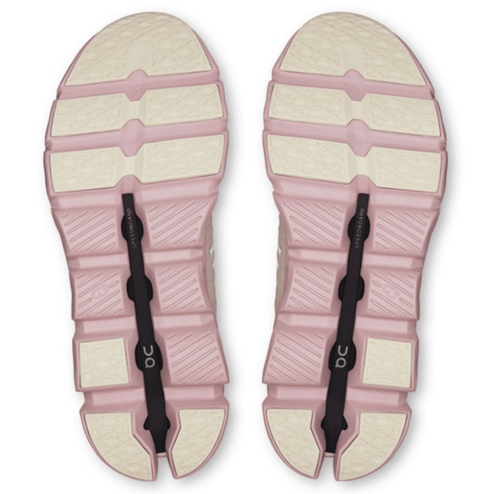 Pair of pink sandals with white soles on a white background