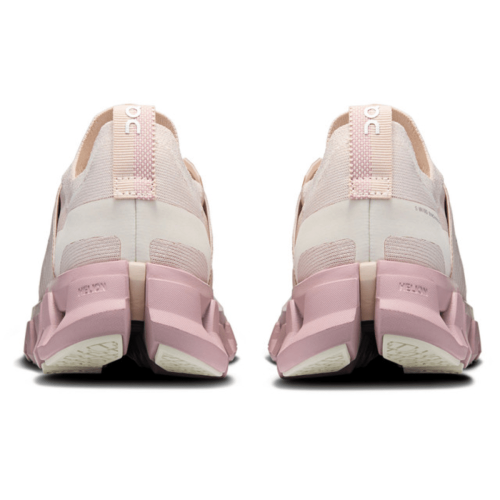 Pink and white running shoes shown from the back on a white background